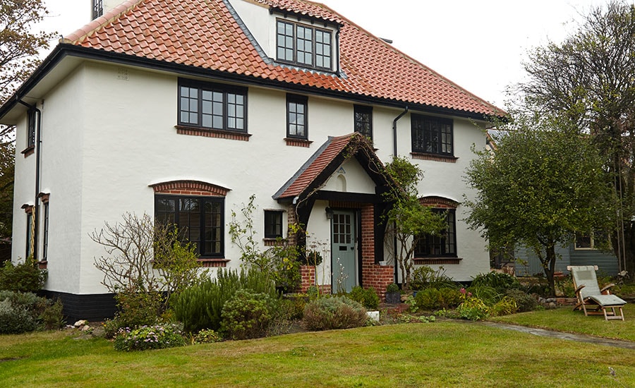 Black timber double glazed casement windows and wooden front door with georgian bars from the Anglian wooden windows and doors range