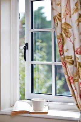 Close up of White timber cottage window with black window handle from the Anglian cottage window range