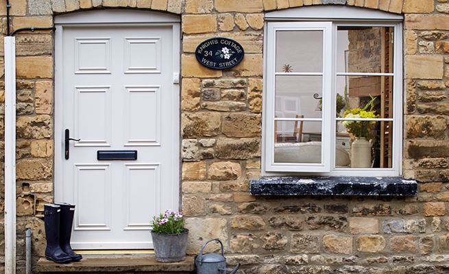 Cream wooden casement window with cottage bars and monkeytail handle and matching traditional door from Anglian Home Improvements