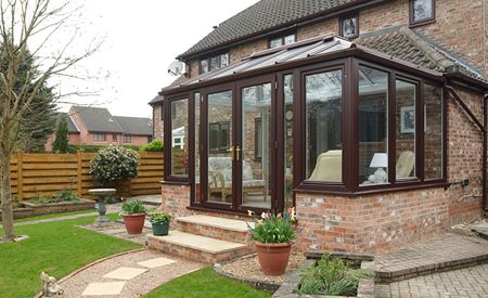 Dark Woodgrain uPVC conservatory with French doors from the Anglian conservatory range