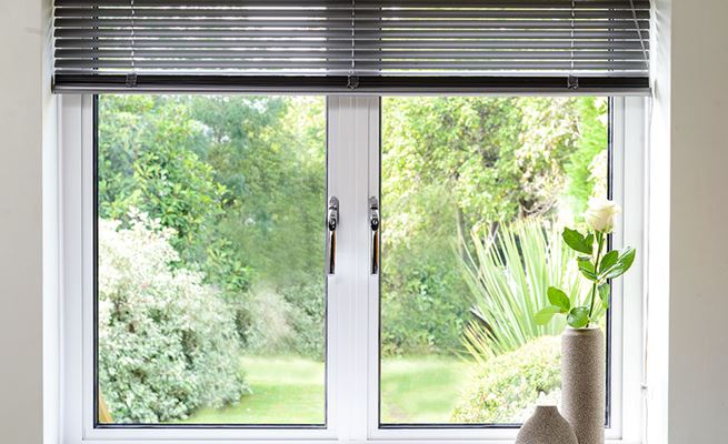 Aluminium double glazed casement window finished in White with chrome handles and blind from Anglian Home Improvements
