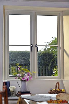Timber cottage window finished in White with centre mullion and black window handles from Anglian Home Improvements
