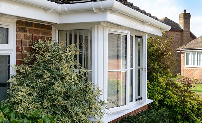 Close up of White uPVC guttering and fascia over bungalow bay window from the Anglian rooftrim range