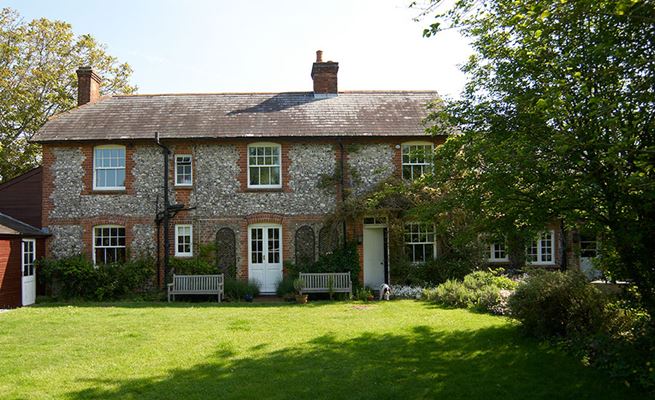 White wooden sash windows and French doors with cottage bars on pebble dash traditional house from Anglian Home Improvements